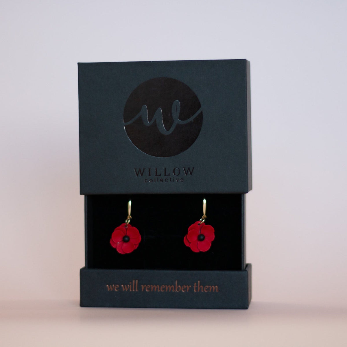 Red poppy earrings in a black box with 'Willow' branding on a light background