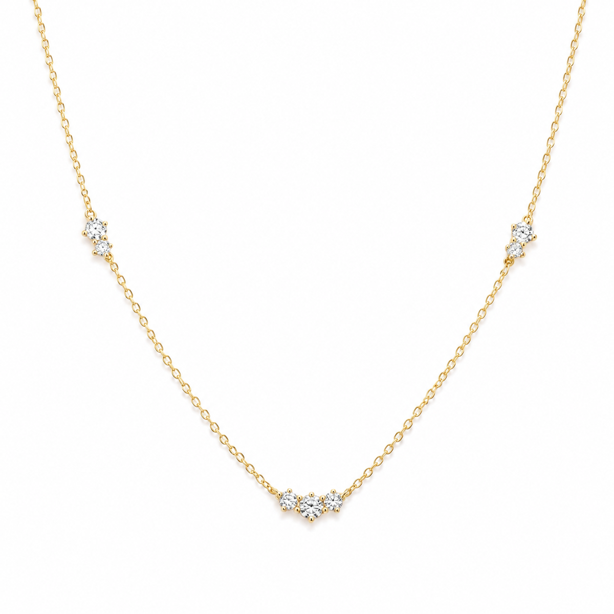 A delicate yellow gold chain necklace featuring three small clusters of clear round-cut gemstones spaced along the chain