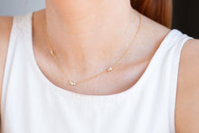Load image into Gallery viewer, Gold necklace with small pendants on a person wearing a white tank top.