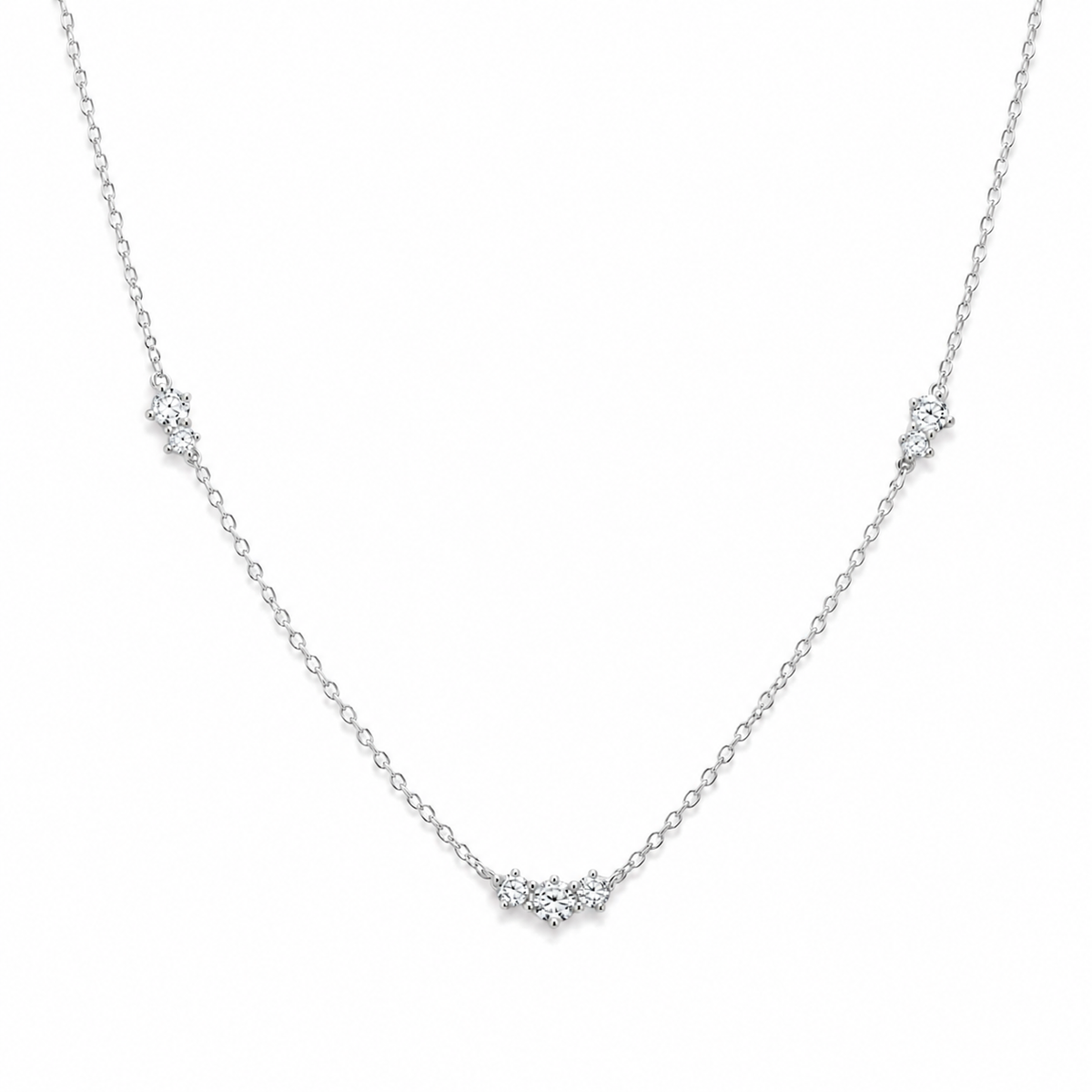 A delicate silver chain necklace featuring three small clusters of clear stones, each set in a star-like cluster design.